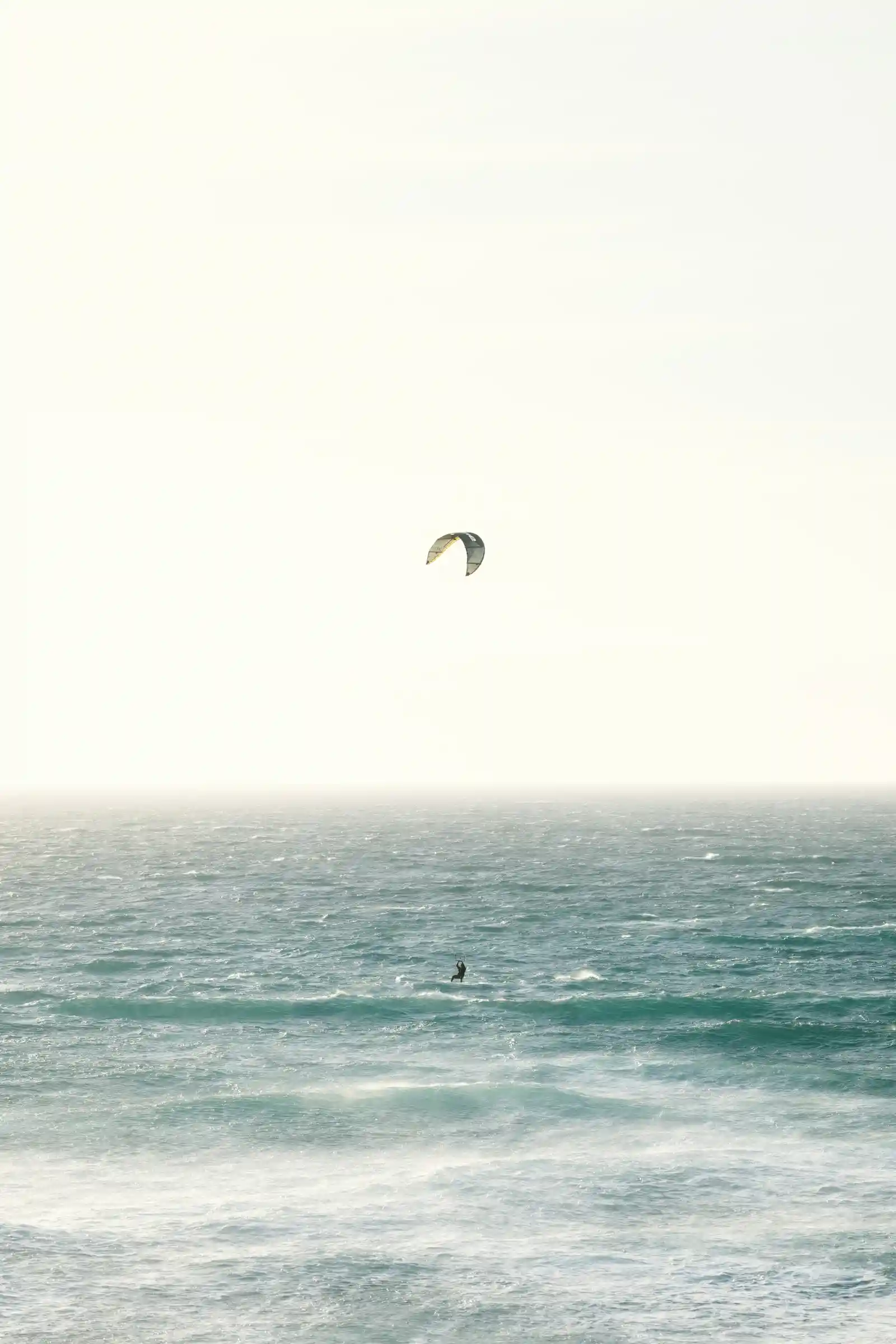 Kitesurfer over hazy ocean waves