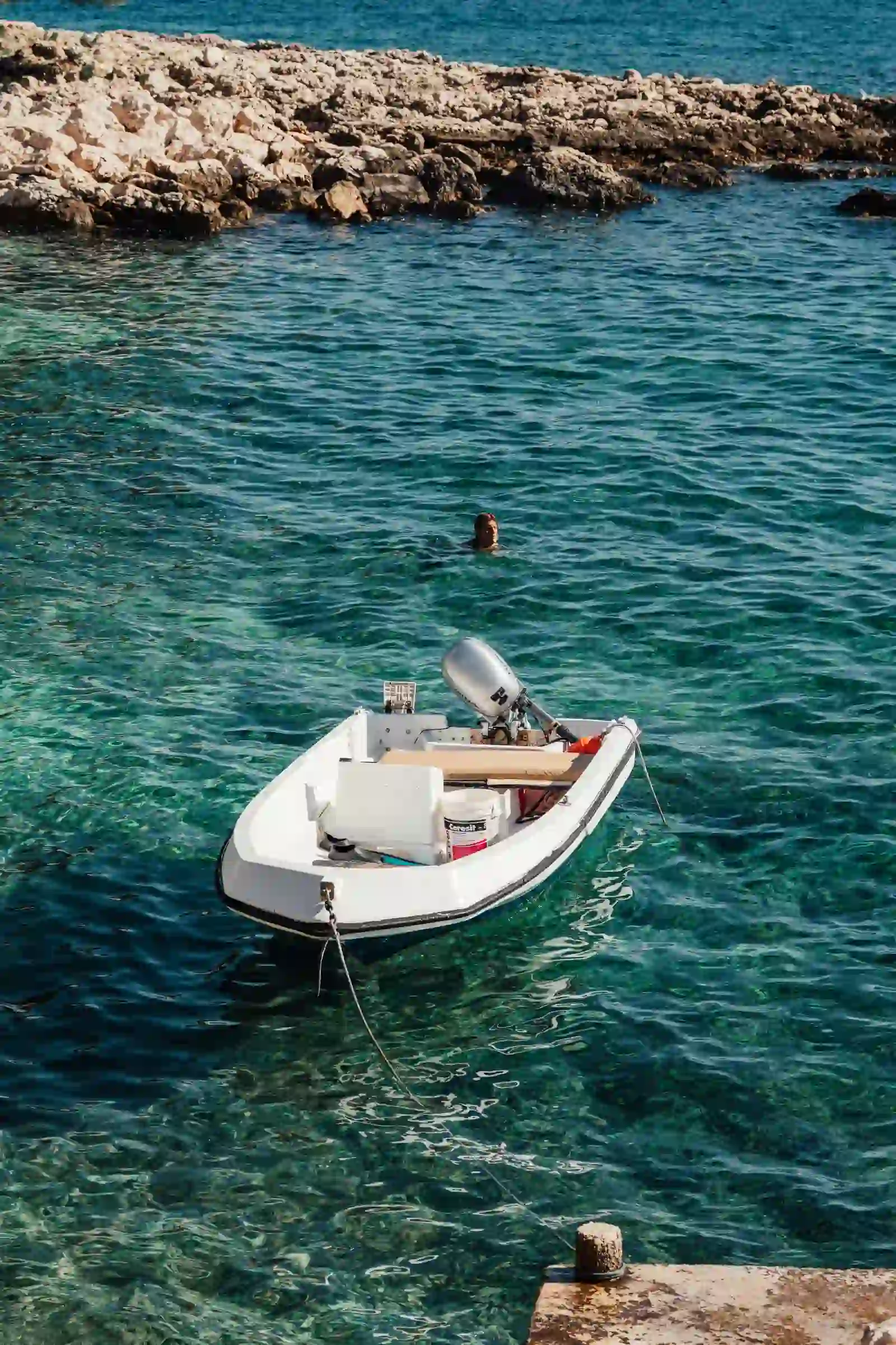 Boat anchored in a clear turquoise cove